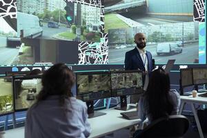 Middle eastern manager explains daily logistics on order tracking activity, ensuring easy delivery and avoiding urban traffic. Employees following the trucks around the city, satellite gps. photo