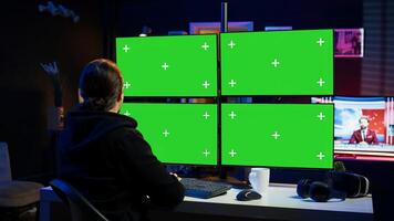 Cybercriminal coding on green screen monitors, developing zero day exploit undetectable by antivirus software. Hacker using mockup PC displays to build script tricking firewalls, camera B photo