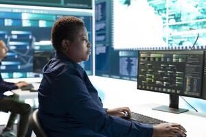 Cyber security experts women working on spyware and malware detection in a governmental agency. Examining server information on a big screen to combat cyberterrorism and cyberwarfare. photo