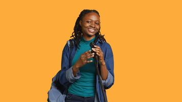 Portrait of african american motivational speaker talking in microphone, addressing audience, isolated over studio background. Expressive lecturer using mic, inspiring motivation, camera A photo