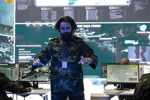 Special operations soldier examines battlefield data on a hologram, working with high tech holographic projection in army command post. Trooper checking defense operation details. photo