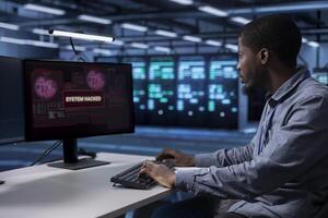 African american engineer in server room frightened by hacker passing company firewall and stealing data. Afraid worker panicking after seeing security breach notification on PC in data center photo