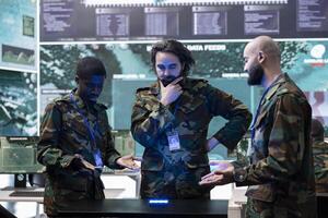 Squad of diverse troopers reviewing crucial real time data on a hologram, discussing ideas for a defense operation. Professional infantry unit soldiers work with holographic projection. photo