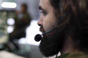 Army recruit working on reconnaissance mission to gather intelligence, operating with global satellite system for surveillance. IT operator working in military headquarters power base. Close up. photo
