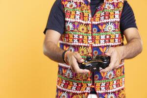 Close up of player pressing triggers on joystick, concentrating on killing foes in videogame. Gamer rotating analog gamepad bumpers in order to beat all enemies in intensive game, studio background photo
