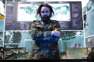 Army officer examining information on a hologram projection in control room, creating a battlefield map for the infantry unit troopers. Soldier monitoring radar surveillance system. photo