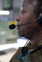 Trained woman engineer monitoring federal surveillance system in army power base, working with a big screen to collect and communicate important real time information. Close up. photo