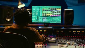 Audio designer leveling sound on a mixer control desk, professional music studio concept. Producer turns up volume and adding effects on a mixing console, recording live tracks. Camera B. photo