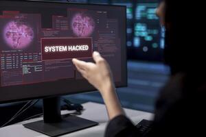 Technician in server room frightened by hacking attack on computers targeting sensitive user data. Close up shot of worker panicking, trying to save data center from unauthorized access photo