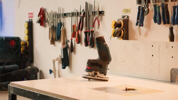 Close up of electric router on wood shaper in carpentry studio used for precision cutting of wood blocks. Focus on power tool on spindle moulder used in woodworking, panning shot photo