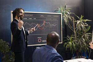 Business expert calculating budgeting plans and goals on interactive board, hosting a meeting to share opinions and details about project to ensure success. Supervisor and staff making decisions. photo