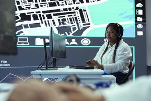 African american call center operator tracks orders for clients, providing updates on delivery truck location. Employee uses gps radar to monitor couriers and ensure express shipping. photo
