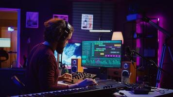 Mastering engineer registering piano keys recordings to edit in daw software on computer, operating his mixing equipment. Artist works on editing and manipulating recorded sounds and tunes. Camera B. photo