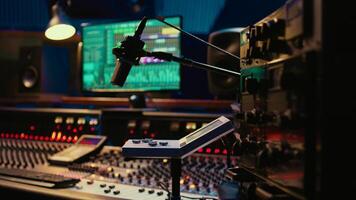 Control room desk equipped with motorized faders and amplifier used in mixing and mastering tracks with audio console. Empty soundproof studio with sliders and switchers on board. photo