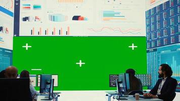 Business partners working in telecommunications control room with a big isolated mockup screen, reviewing key performance indicators within the enterprise activity. Conducting evaluations. Camera A. photo