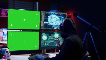 Cybercriminal using AI deep learning to produce virus corrupting data on mockup PC. Rogue developer working on isolated screen computer using artificial intelligence, penetrating security, camera B photo