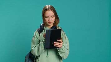 Woman scrolling on tablet touchscreen, checking social media feed, catching up with friends. Happy person relaxing by browsing internet websites, isolated over studio background, camera A photo