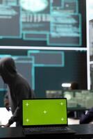 Laptop showing green screen in a governmental high tech office, cyber security team working on network security and data protection. Focusing on ransomware and other cyber threats. photo