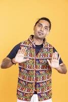 Portrait of passive aggressive man doing slow down hand gesture sign, giving caution. Angry person doing zealous halt sign gesturing, interrupting, isolated over studio backdrop photo