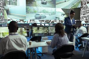 Indian supervisor and his staff following their delivery cars in traffic, finding best routes through surveillance CCTV cameras to provide coordinates to the couriers. Control center satellite map. photo