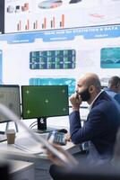 Finance advisor examining current business situation with isolated chroma key display, ensuring organizational progress and overall success. Skilled consultant reviews the budget numbers. photo