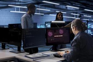 Admin in server hub trying to protect hardware from hacker attack stealing sensitive information. Data center employee struggling to erase virus after seeing security breach alert on monitor photo