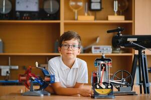 Physics lesson. A student at a desk with scientific instruments and a telescope photo