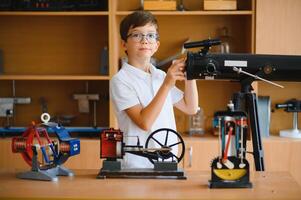 Physics lesson. A student at a desk with scientific instruments and a telescope photo