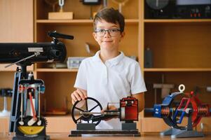 Physics lesson. A student at a desk with scientific instruments and a telescope photo