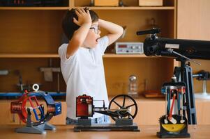 Physics lesson. A student at a desk with scientific instruments and a telescope photo