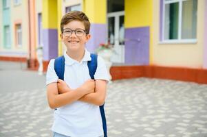 Back to school. Pupil of primary school on the way to study. Little first grader in glasses and with school bag photo