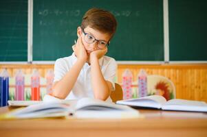 Portrait of little boy studying in classroom at school photo