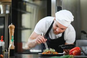 Portrait of happy caucasian male chef standing in restaurant kitchen, copy space photo