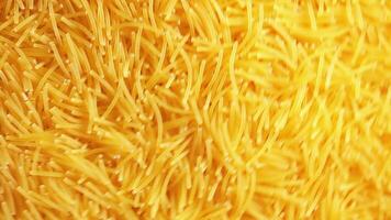 Background of Uncooked Noodles that Slowly Rotating Clockwise - Top View, Angular Rotation. Texture of Dry Vermicelli Turning Around. Raw Pasta with Low Key Light - Right Rotation video