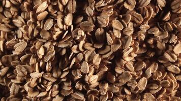 Oat Flakes Background Slowly Rotating Right - Top View, Low Key Light. Scattered Dry Oat Flakes. Healthy Breakfast and Diet Eating Ingredients video
