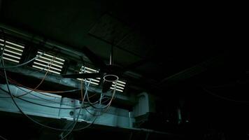 Wires hanging from the ceiling in a dimly lit room with a concrete interior video
