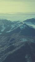 large snow patch left over on the volcanic rock field of a mountain in summer video
