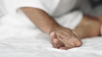 A close-up of a couple's hands intertwined on the bed, capturing a moment of relaxation. This scene conveys the connection and pleasure in their loving relationship video