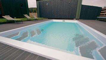 Clean Modern Pool with Relaxing Lounge Chairs on Wooden Deck video