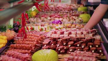 Man hands in gloves placing a tray full of pieces of meat on skewers. video