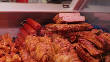 Freshly smoked sausage and ham on the counter of Butchers shop. video