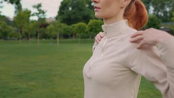 Woman warming up arms in the park morning, side view. video