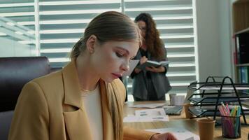 Woman working using laptop looking through analytic data. video
