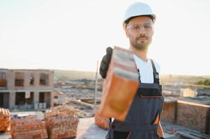 Construction worker in uniform and safety equipment have job on building photo