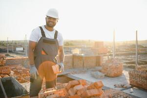Indian Construction worker in uniform and safety equipment have job on building photo