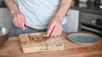 man slicing Salted pickles with knife from jar can, Cucumbers preservations, conservation. Salted pickled cucumbers in a wooden table. Preparing the salad video