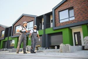 Building inspector and builder inspecting new cottage complex photo