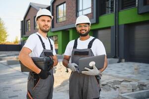 Building inspector and builder inspecting new cottage complex photo