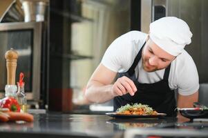 Chef cook in uniform cooking in the big cooker at the restaurant kitchen photo
