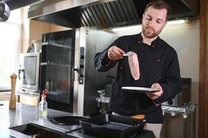 Chef cook in uniform cooking in the big cooker at the restaurant kitchen photo